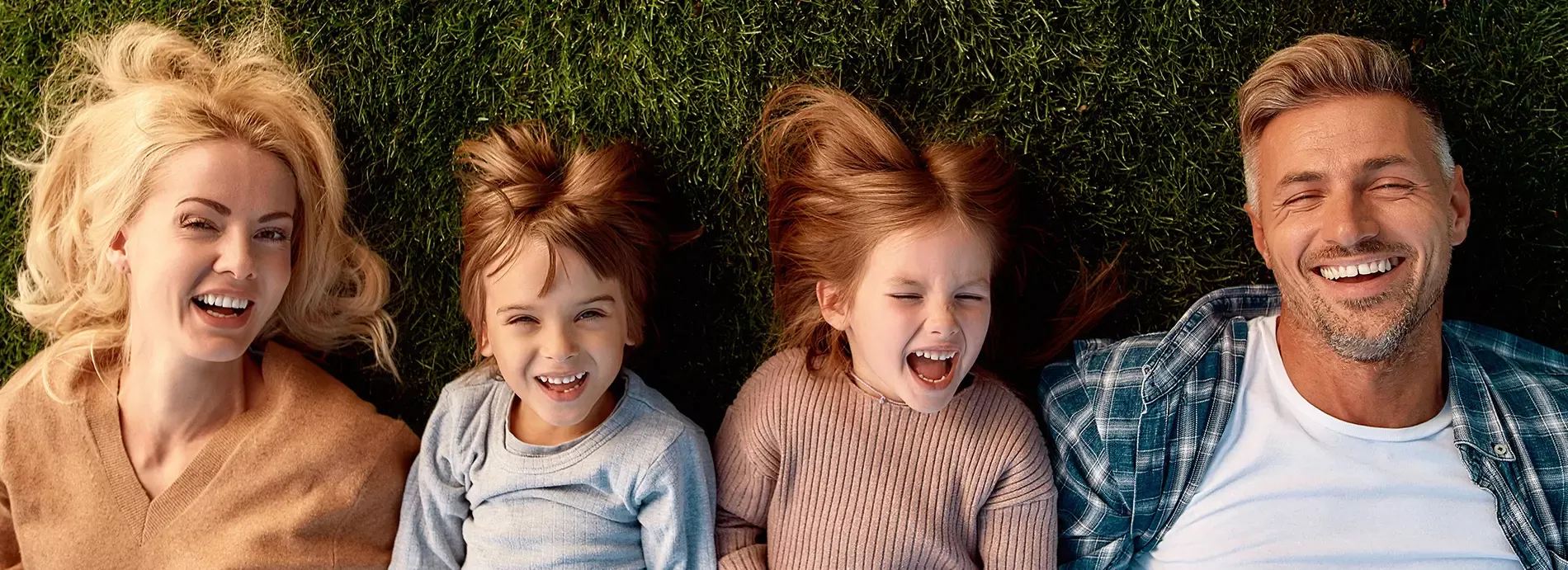 Family laying together in grass