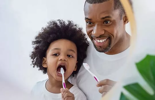 Father and son brushing teeth